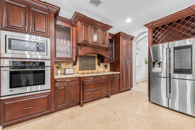 kitchen featuring stainless steel appliances, light stone countertops, backsplash, and ornamental molding