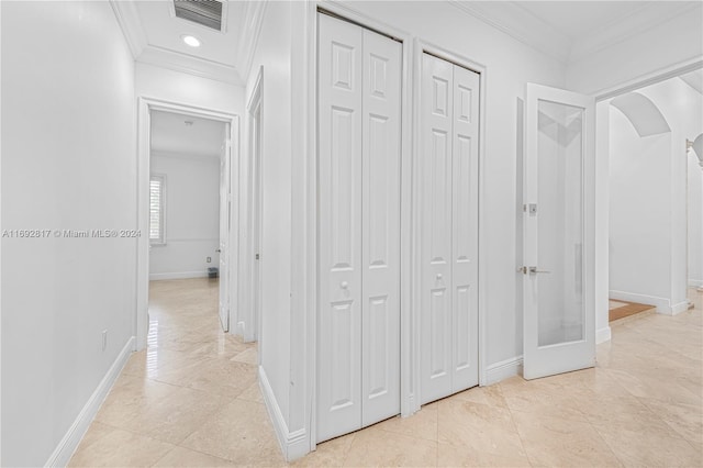 corridor with light tile patterned flooring and ornamental molding