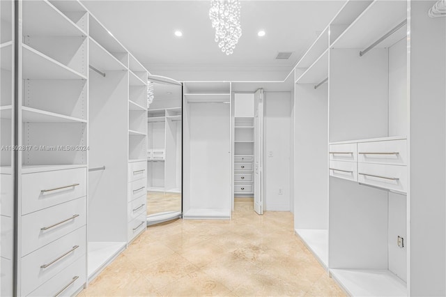 spacious closet featuring an inviting chandelier