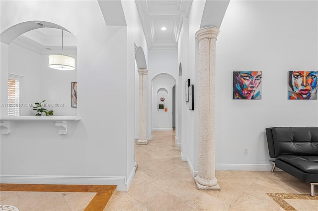 hall with a tray ceiling, ornate columns, and crown molding