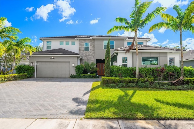 mediterranean / spanish house featuring a garage and a front lawn