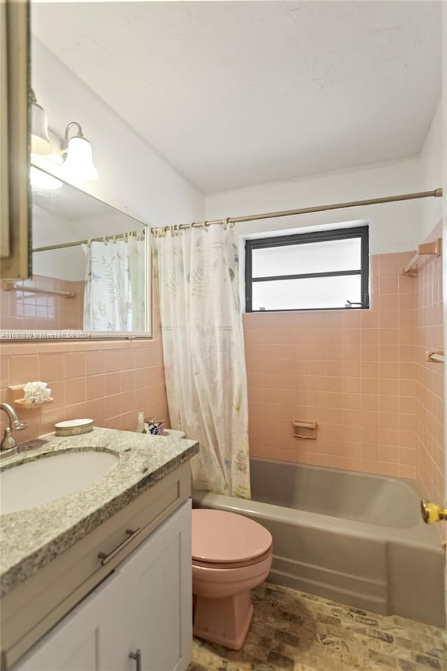 full bathroom featuring shower / tub combo, tasteful backsplash, vanity, tile walls, and toilet