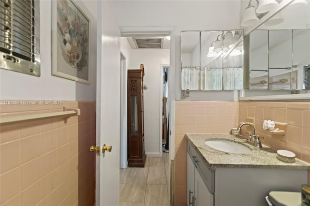 bathroom with vanity and tile walls