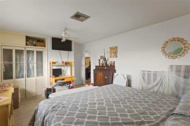 bedroom featuring a closet, light hardwood / wood-style flooring, and ceiling fan