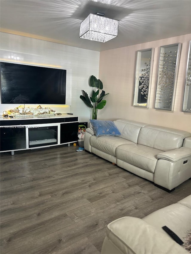 living room with dark wood-type flooring and a chandelier