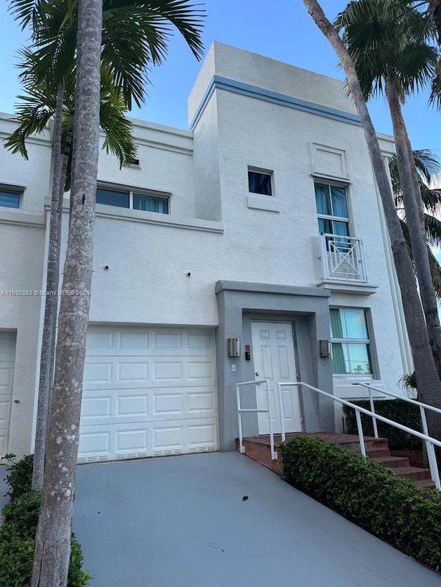 view of front facade with a garage and a balcony