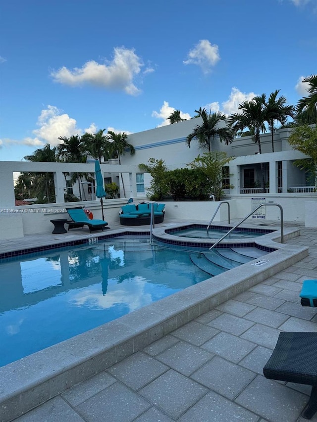 view of pool featuring a hot tub and a patio