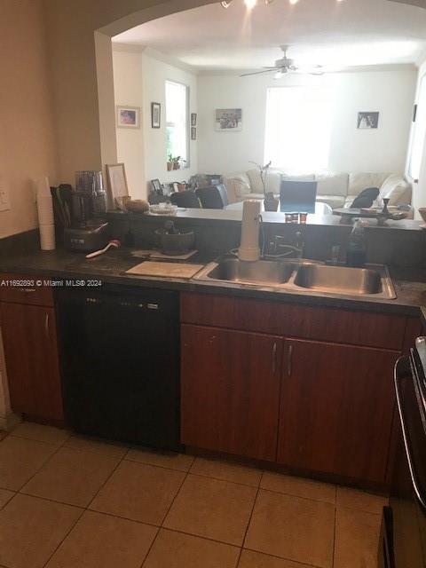 kitchen featuring black dishwasher, stove, light tile patterned floors, sink, and ceiling fan