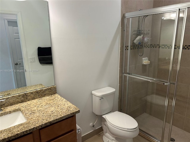 bathroom with vanity, toilet, and a shower with shower door