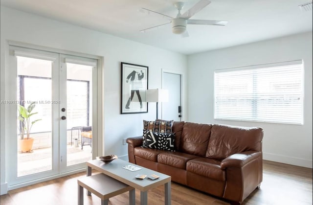 living room featuring light wood-type flooring, ceiling fan, and plenty of natural light