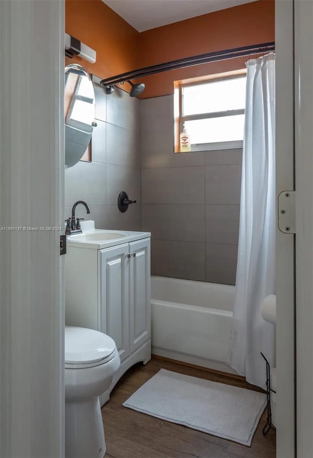 full bathroom featuring wood-type flooring, vanity, toilet, and shower / tub combo with curtain