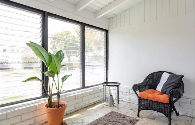 sunroom featuring vaulted ceiling with beams