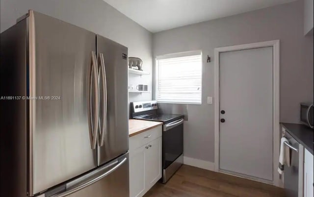 kitchen with white cabinets, light wood-type flooring, and appliances with stainless steel finishes