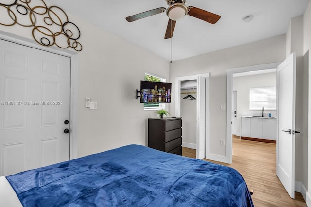 bedroom with sink, hardwood / wood-style floors, and ceiling fan