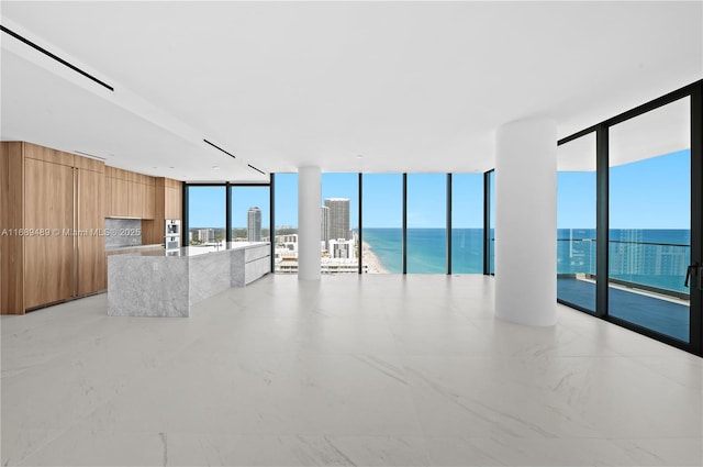 2000 S Ocean Dr Unit 27A, Hallandale Beach, FL 33009 - unfurnished living room featuring a wall of windows, a water view, light marble finish floors, and a city view