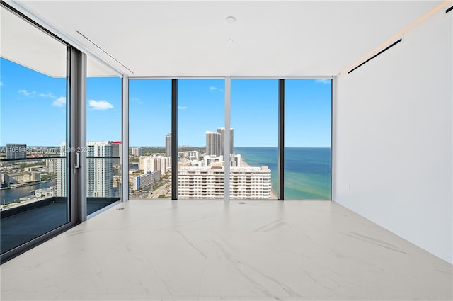 unfurnished room with a water view and floor to ceiling windows