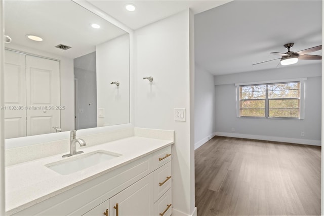 bathroom featuring hardwood / wood-style flooring, vanity, and ceiling fan