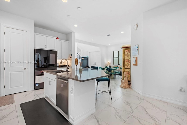 kitchen with white cabinetry, sink, an island with sink, a breakfast bar area, and dishwasher