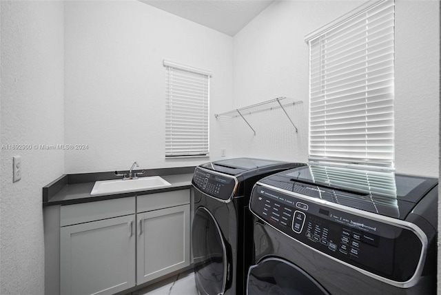 laundry room with independent washer and dryer, cabinets, and sink