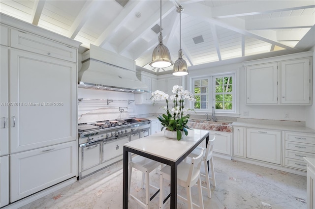 kitchen featuring pendant lighting, stainless steel gas cooktop, custom range hood, and white cabinets