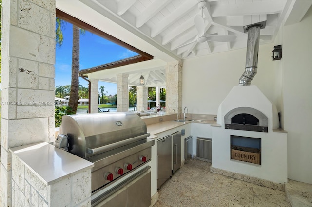 view of patio with area for grilling, a grill, sink, and ceiling fan