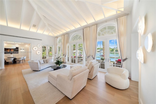 sunroom / solarium with vaulted ceiling with beams, french doors, and a water view