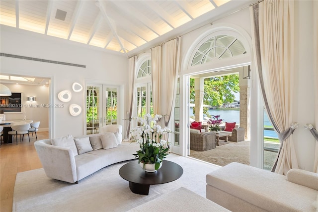 sunroom / solarium featuring a water view, vaulted ceiling with beams, wood ceiling, and french doors