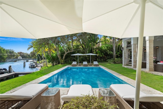 view of swimming pool featuring a water view and a yard