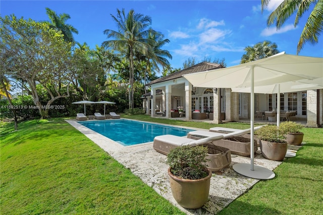 view of pool with french doors, a yard, and a patio