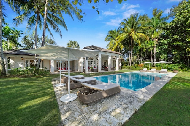 view of swimming pool with a patio, a lawn, and french doors