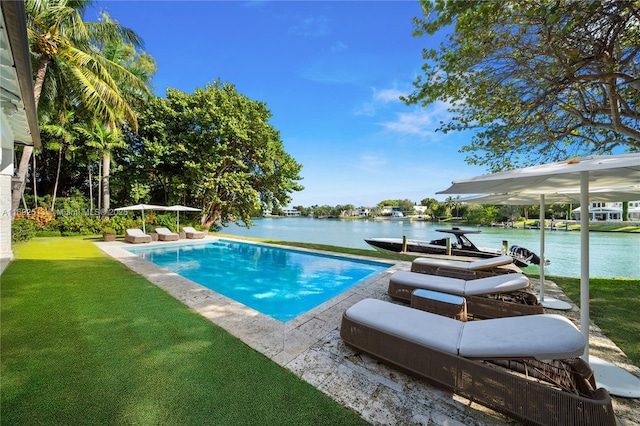 view of pool with a lawn and a water view