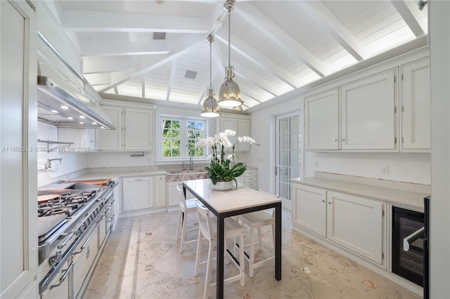 kitchen with pendant lighting, premium range hood, vaulted ceiling with beams, wine cooler, and white cabinets