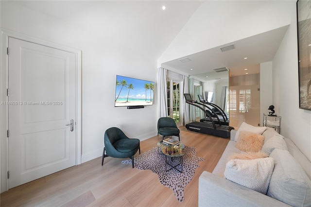 living room with high vaulted ceiling and light hardwood / wood-style flooring