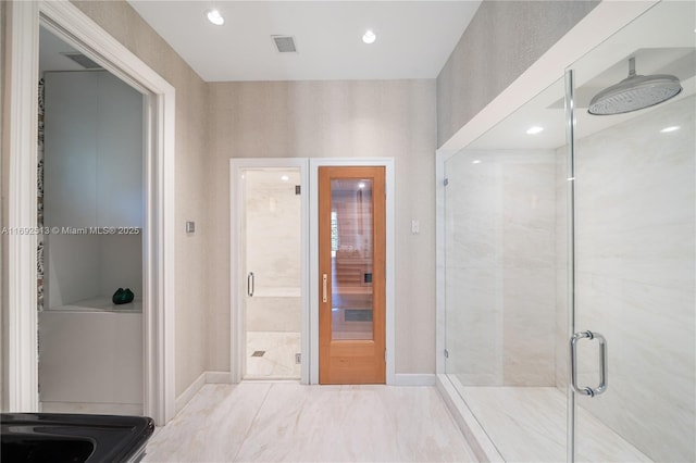 bathroom featuring a shower with door