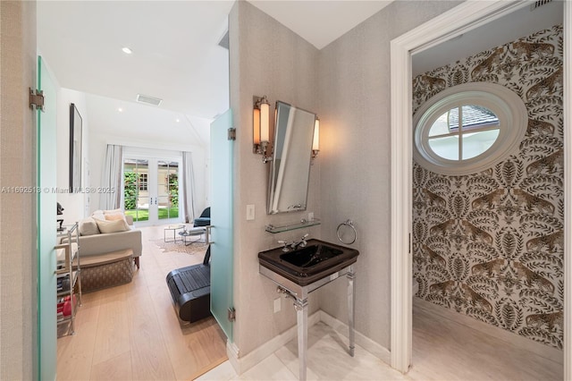 bathroom featuring french doors, sink, and hardwood / wood-style floors