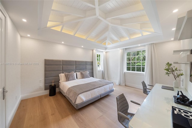 bedroom featuring light hardwood / wood-style flooring and vaulted ceiling with beams