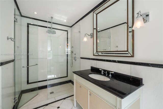 bathroom featuring vanity, tile walls, and walk in shower