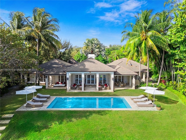 rear view of property with a patio, outdoor lounge area, and a lawn