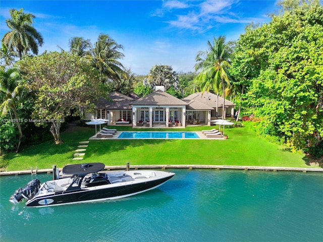 view of swimming pool featuring a water view, a yard, and a patio