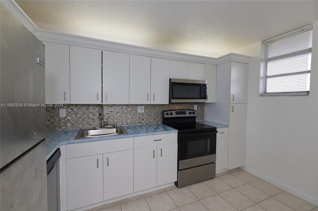 kitchen featuring stainless steel appliances, white cabinetry, sink, and tasteful backsplash