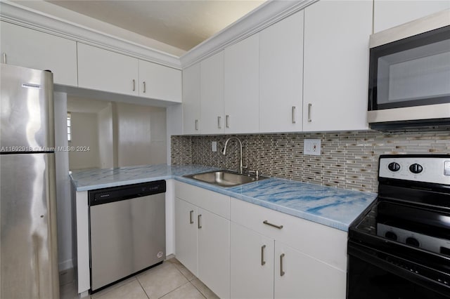 kitchen with white cabinetry, stainless steel appliances, sink, and light tile patterned flooring