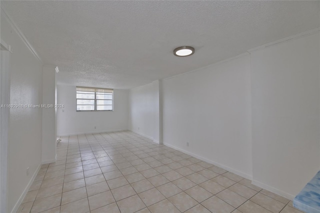 tiled empty room featuring a textured ceiling