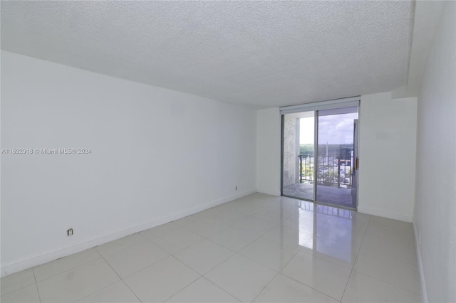 tiled spare room with a textured ceiling