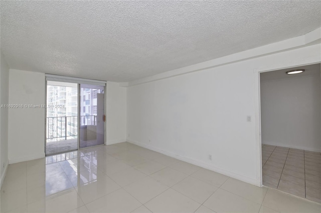 empty room featuring light tile patterned flooring and a textured ceiling