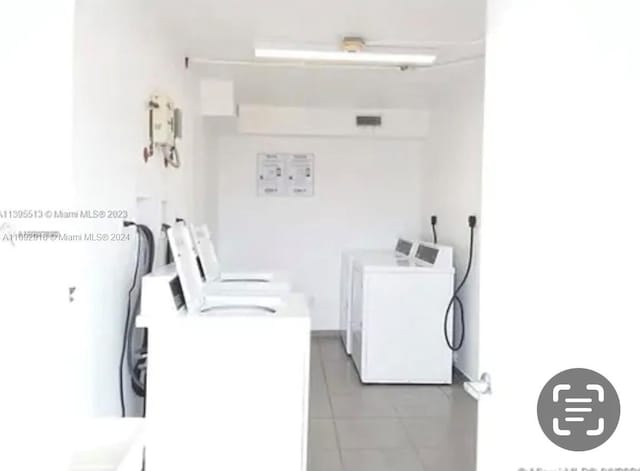 laundry area featuring washer and clothes dryer and light tile patterned floors