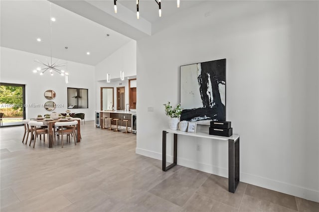 dining area featuring high vaulted ceiling and an inviting chandelier