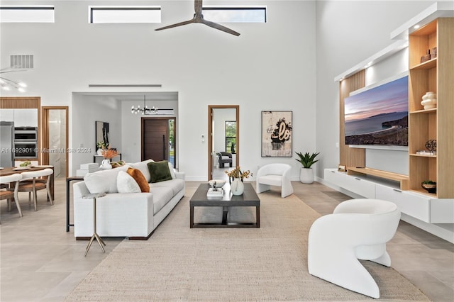 living room featuring a high ceiling and ceiling fan with notable chandelier