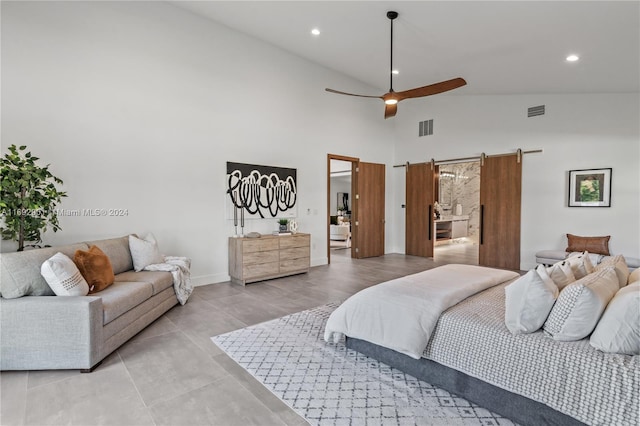 bedroom featuring a barn door, ceiling fan, light wood-type flooring, and high vaulted ceiling