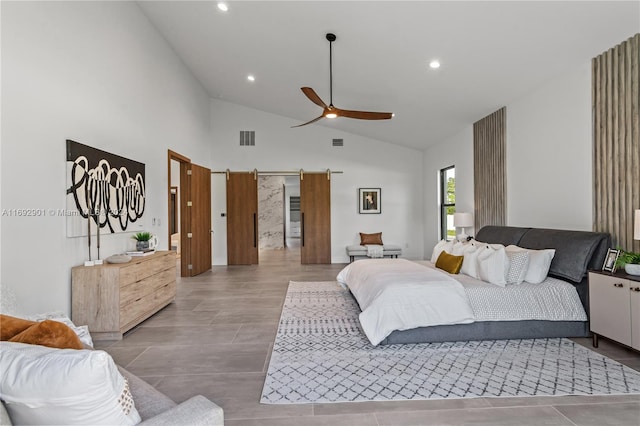 bedroom featuring a barn door, ceiling fan, and high vaulted ceiling