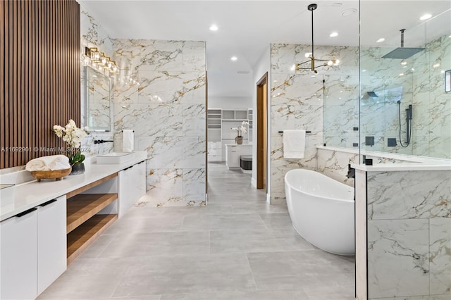 bathroom with tile walls, a notable chandelier, separate shower and tub, and vanity